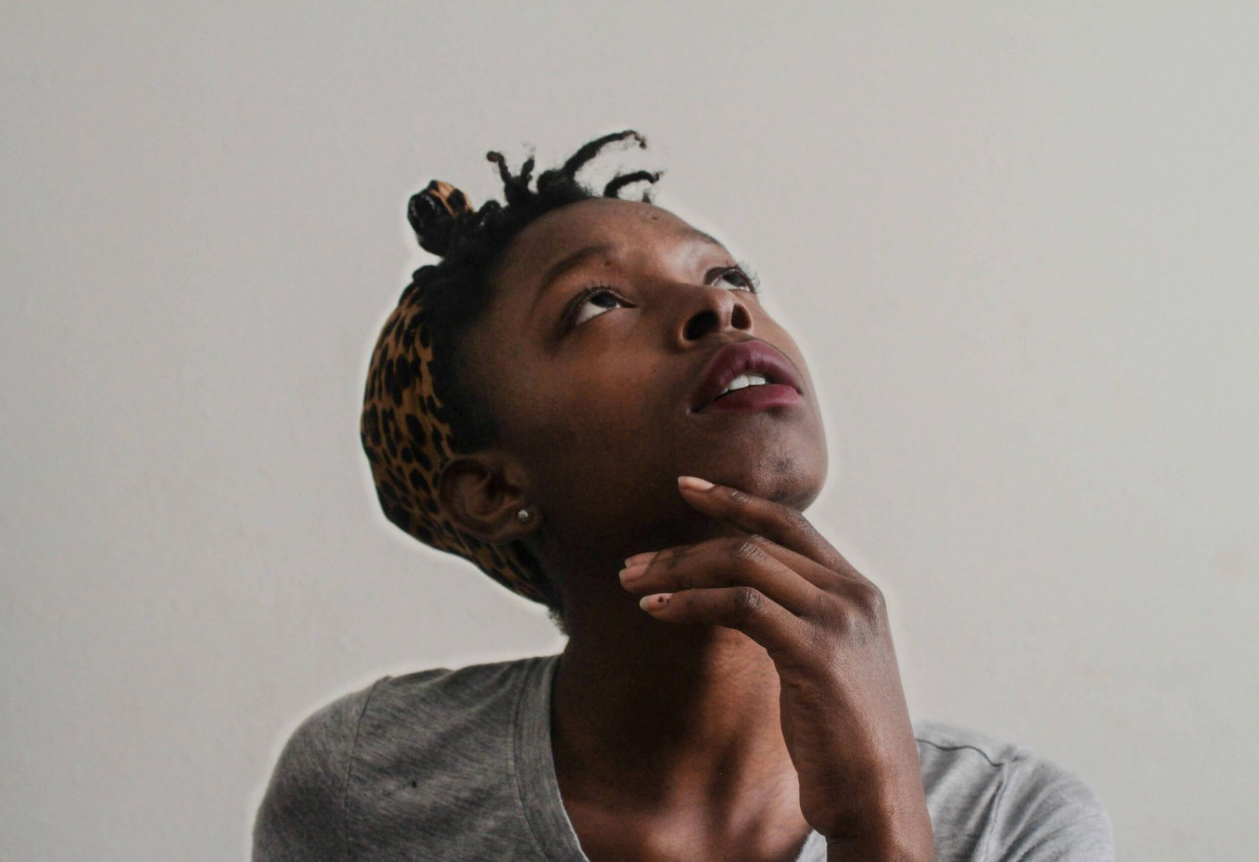 Woman looking up with hand on chin