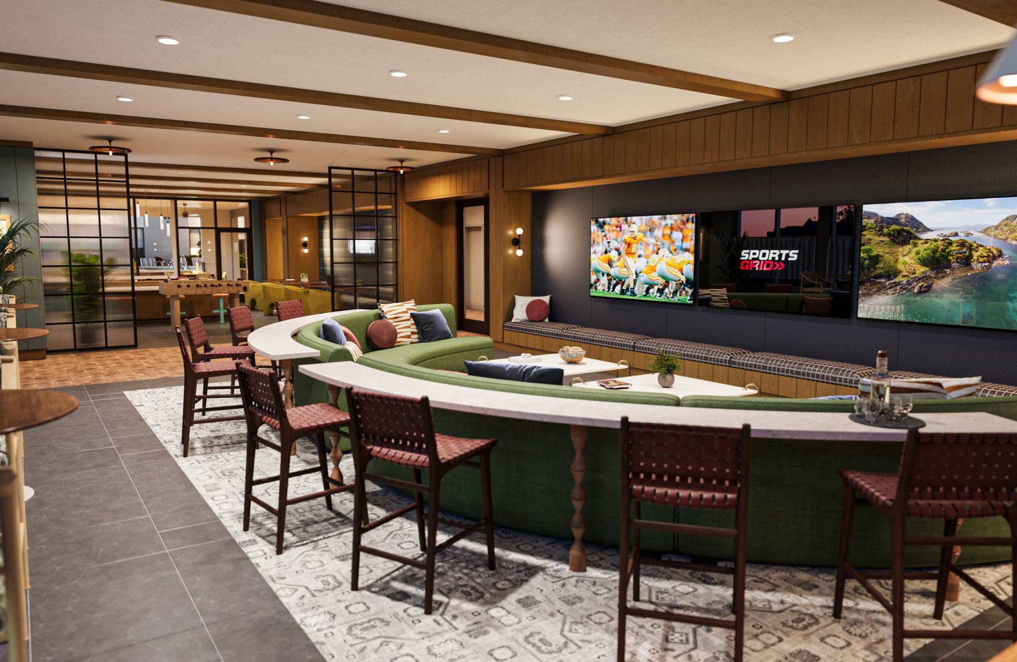 EVER Knoxville apartments Modern lounge with a curved green sofa, wall-mounted TVs, bar stools, and warm, stylish decor.